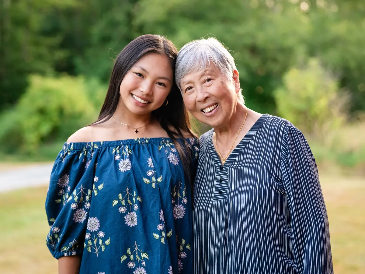 Grandmother and granddaughter smiling together outdoors