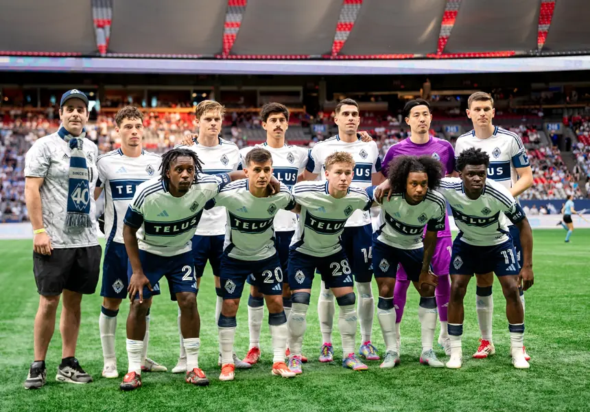 Professional soccer team posing on the field before a match