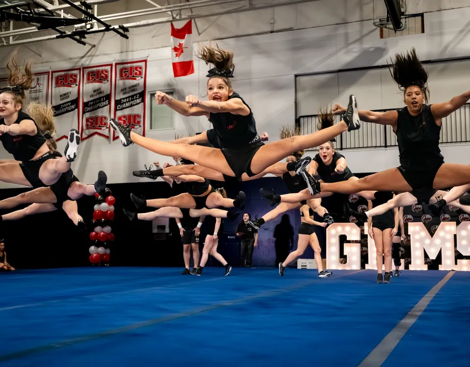Cheer athletes performing synchronized jumps at a competition